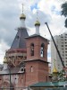 Завершение северного и западного фасадов строящейся церкви Серафима Саровского в Восточном Дегунино в Москве. Справа главка временной церкви.